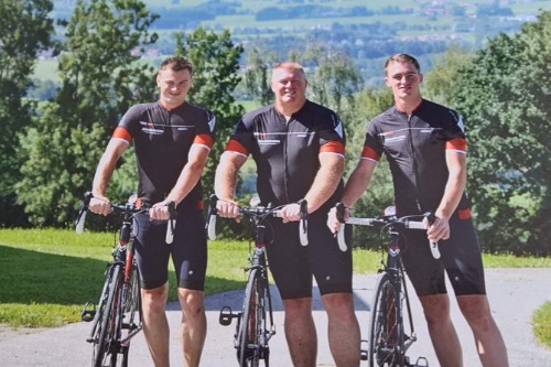 Buurtsportcoach Rick links op de foto met wielrenfiets, samen met vader en broer in Duitsland