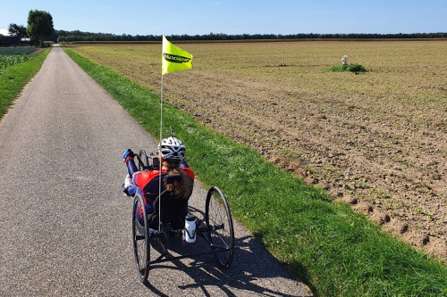 Ingrid de Waal op een handbike over een polderweg